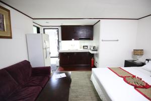 Habitación con cama, sofá y cocina. en Hotel Asia Cebu, en Cebú