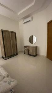 Habitación blanca con espejo y mesa en الدانه 2, en Hafr Al Batin