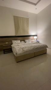 Un dormitorio con una cama en una habitación blanca. en الدانه 2, en Hafr Al Batin