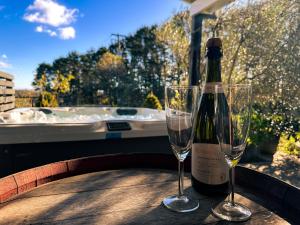 a bottle of wine sitting on a table with two glasses at The Grange Berrima - The Ultimate Rural Retreat in Berrima