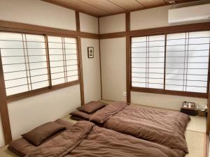 a bed in a room with three windows at ATW Tokyo Near the station Close to Asakusa Airport For infants and toddlers in Tokyo