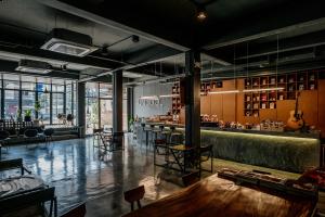 ein Raum mit einer Bar mit Tischen und Stühlen in der Unterkunft Sleep Station in Surat Thani