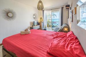 a red bed with a stuffed animal sitting on top of it at Le Flamboyant - Balcon vue mer - Wiskeys in Saint-Gilles les Bains +22 photos