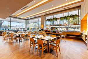 a restaurant with tables and chairs and large windows at Clarion Suites Gateway in Melbourne
