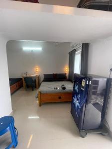 a bedroom with a bed and a desk and a table at Caribbean Island Home Stay in Mahabalipuram