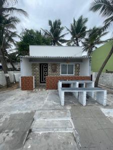 a house with a bench in front of it at Caribbean Island Home Stay in Mahabalipuram +3 photos