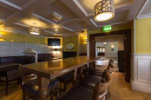 uma grande sala de jantar com uma mesa longa e cadeiras em Ballyliffin Hotel em Ballyliffin