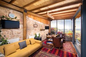a living room with a couch and a tv at The Rupestral House Hotel in Uçhisar