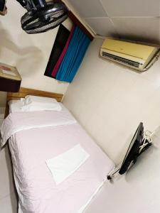 香港cebu hostel的小房间的小床,配有笔记本电脑