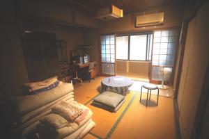 郡上市にある民泊 菅田 金物屋のおばあちゃんち 下呂市金山町菅田のソファとスツールのあるリビングルーム