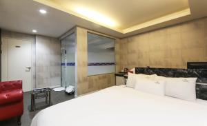 Postel nebo postele na pokoji v ubytování Songjeong V Hotel