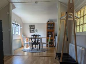 a dining room and living room with a table and chairs at Gunnabo in Borgholm +2 photos