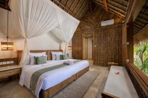 a bedroom with a large bed in a room at The Mesare Eco Resort in Nusa Penida