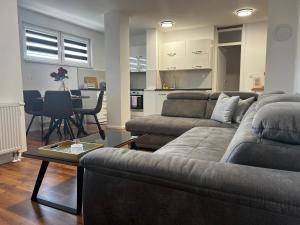 a living room with two couches and a dining room at Apartman Nora in Teslić