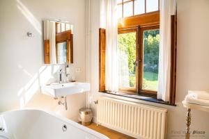 ein Badezimmer mit Badewanne und Waschbecken und einem Fenster in der Unterkunft Les Sorbiers in Heer