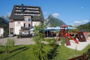 un parque infantil con un tobogán frente a un edificio en Hotel Mangart en Bovec