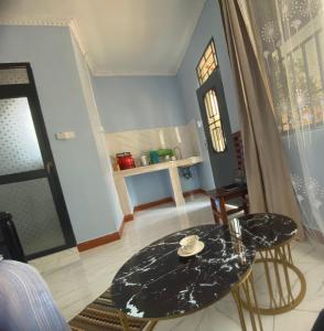 a table and chairs in a room with a window at Anne studio & Home stay in Mwanza