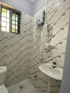 a bathroom with a sink and a toilet at Anne studio & Home stay in Mwanza