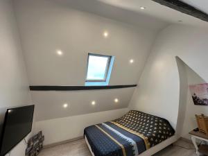 a small attic bedroom with a bed and a window at maison 4 personnes tout confort alentours boulogne sur mer in Samer