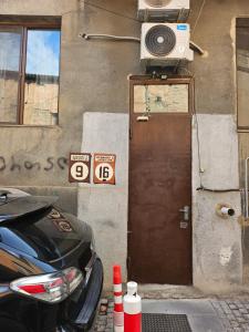 a door to a building with a camera and a car at Guesthouse Kato in Tbilisi City
