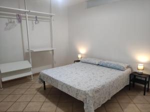 a bedroom with a bed and two lamps on two tables at Casa vacanza Leuca in Leuca