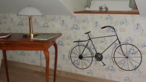 a bike hanging on a wall next to a desk at B&B Les Cistelles in Saint-Nicolas-lès-Cîteaux