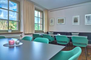 a waiting room with tables and green chairs at Ev.Familienferien-und Bildungsstätte Ebernburg in Bad Münster am Stein-Ebernburg