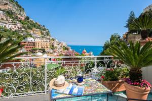 una mesa con un sombrero en la parte superior de un balcón en Hotel Royal Prisco, en Positano