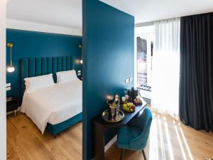 ein blaues Schlafzimmer mit einem Bett und einem Tisch in der Unterkunft Regola Luxury Relais in Rom