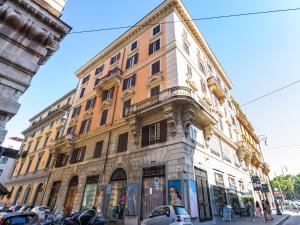 ein großes Gebäude in einer Stadtstraße mit parkenden Autos in der Unterkunft Regola Luxury Relais in Rom