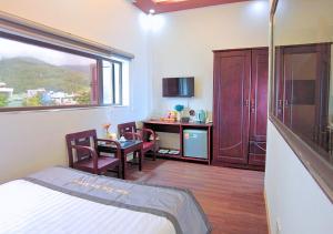a bedroom with a bed and a table and a desk at Sontra Sea Hotel in Danang