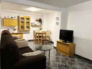 a living room with a couch and a tv at Casa ' A ca Paca ' in Lanjarón