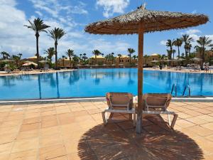 stół z parasolem przed basenem w obiekcie Casa Manba, terrace, pool and wifi w Corralejo