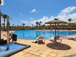 basen z dwoma krzesłami i parasolem w obiekcie Casa Manba, terrace, pool and wifi w Corralejo