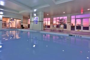 a swimming pool with blue lights in a building at Holiday Inn & Suites Bakersfield by IHG in Bakersfield