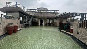 a house with a green tile floor in front of it at Riverfront Penthouse Studio with Spacious Terrace in Lucknow