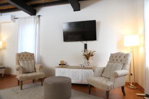 a living room with two chairs and a flat screen tv at Room&Breakfast Villa Angela in Sala Baganza
