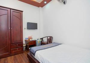 a bedroom with a bed and a desk and a tv at Sontra Sea Hotel in Danang