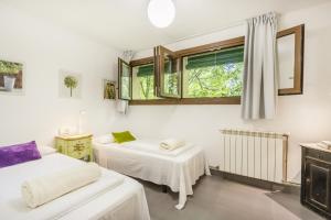 a room with two beds and a window at Casa Dels Peixos in La Baronia de Rialb