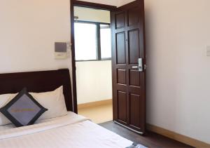 a bedroom with a bed and a open door at Sontra Sea Hotel in Danang