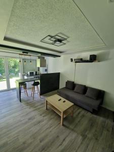 a living room with a couch and a table at Logement Atypique & Parking GRATUIT in Gex