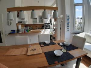 a kitchen with a wooden table with bowls on it at Gemütliche Wohnung mit geteiltem Essbereich am Rande des Bremer Viertel in Bremen