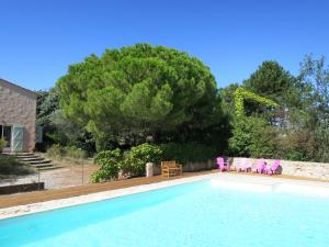 a swimming pool with chairs and a tree at Domaine de Courbieres in Laurac