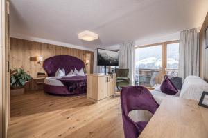 sypialnia z łóżkiem z fioletowym zagłówkiem w obiekcie Boutiquehotel die Alpbacherin 4 Sterne Superior w Alpbach