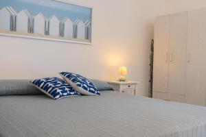 a bedroom with a bed with blue and white pillows at Relax nel Centro Storico in San Nicola Arcella