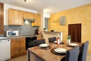 eine Küche mit einem Holztisch mit Stühlen und einem Esszimmer in der Unterkunft Résidence Armagnac - City Center in Carcassonne