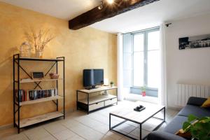 ein Wohnzimmer mit Sofa und Fernseher in der Unterkunft Résidence Armagnac - City Center in Carcassonne