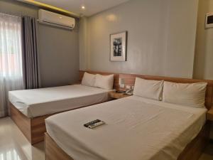 ein Hotelzimmer mit 2 Betten und einem Telefon darauf in der Unterkunft hanguk hotel 한국 호텔 in Angeles + 26 Fotos