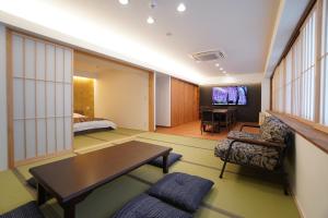 una camera d'albergo con un letto e un soggiorno di Bird Hostel Palace Side Suite a Shimmachidōri