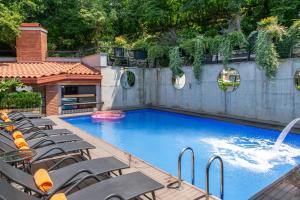 a swimming pool with chairs and a fountain at Seventeen Rooms in Tʼelavi